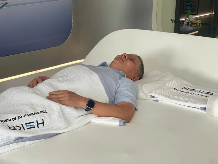 A visitor lying on their back feeling the AI mattress at the HEKA Experience Center