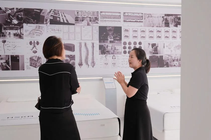 A visitor talking with a Sleep Consultant by the R&D information wall