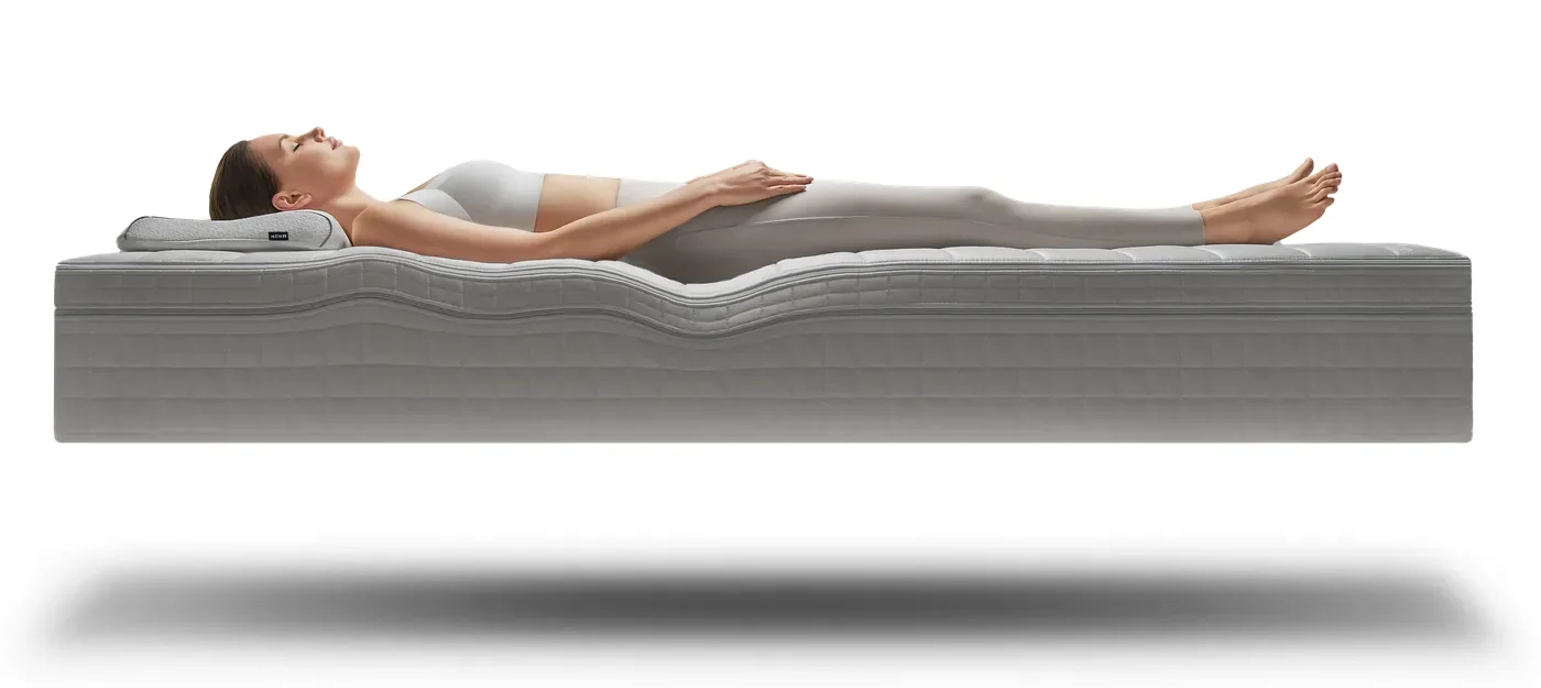 A lighter person lying on their back on the HEKA AI Mattress, the surface adjusting by a different amount