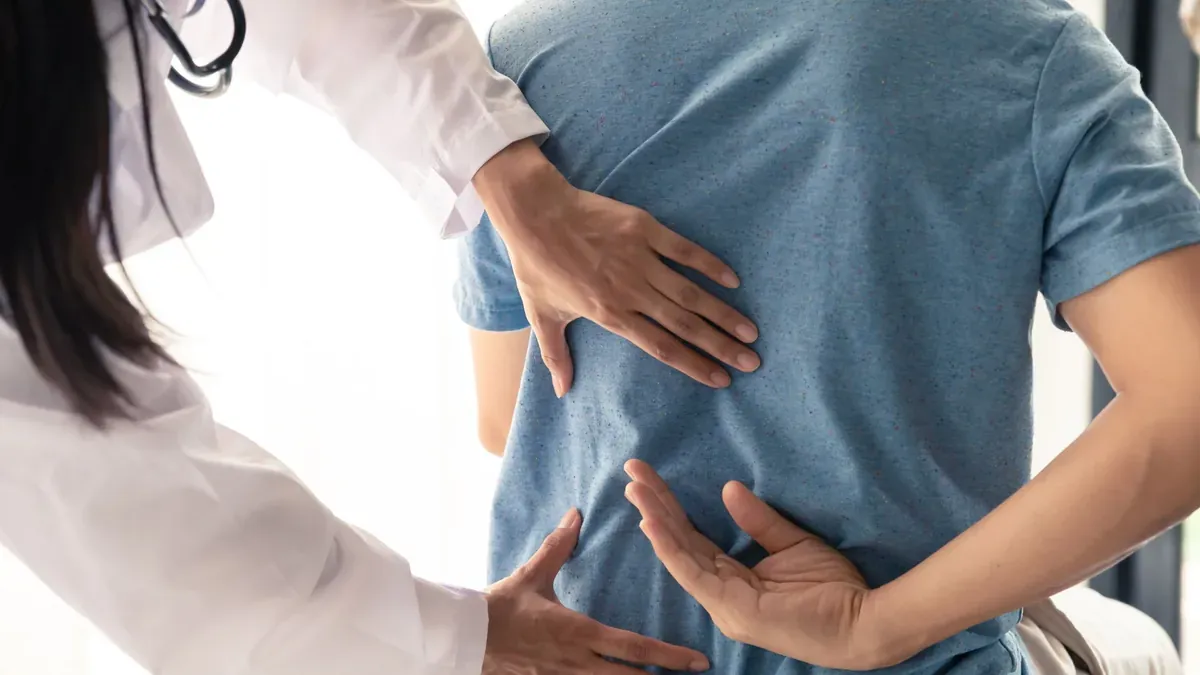 Bác sĩ thăm khám cột sống thắt lưng để tìm nguyên nhân gây đau